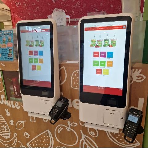 Two wall mounted juice ordering kiosks in a juice bar.